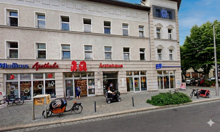 Blick auf ein Straßenszenario mit Geschäften und Fahrradtaxis in einer städtischen Umgebung.